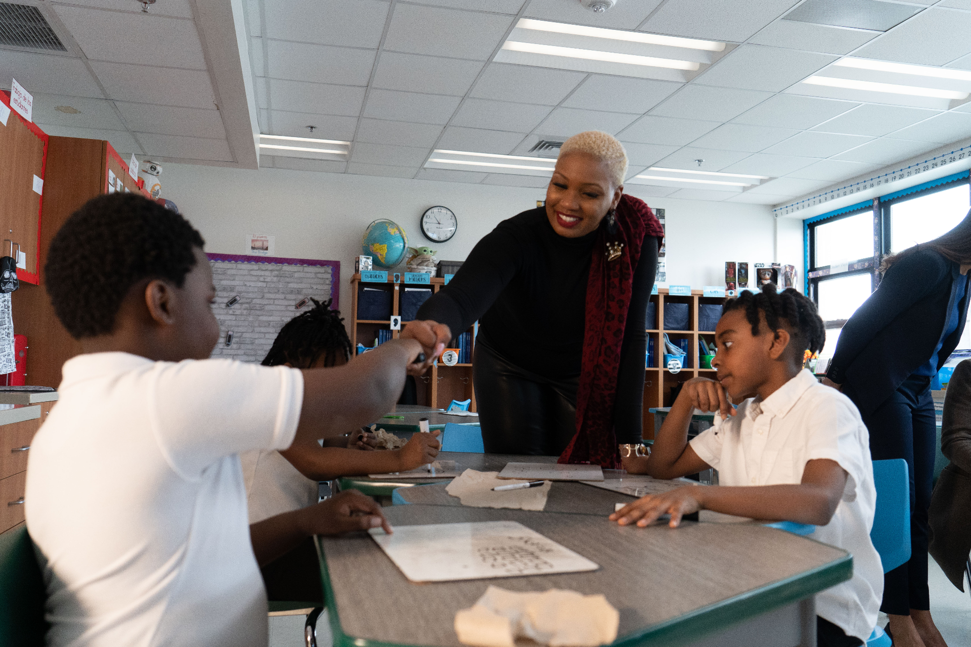 Taji giving a student a fist bump in the classroom